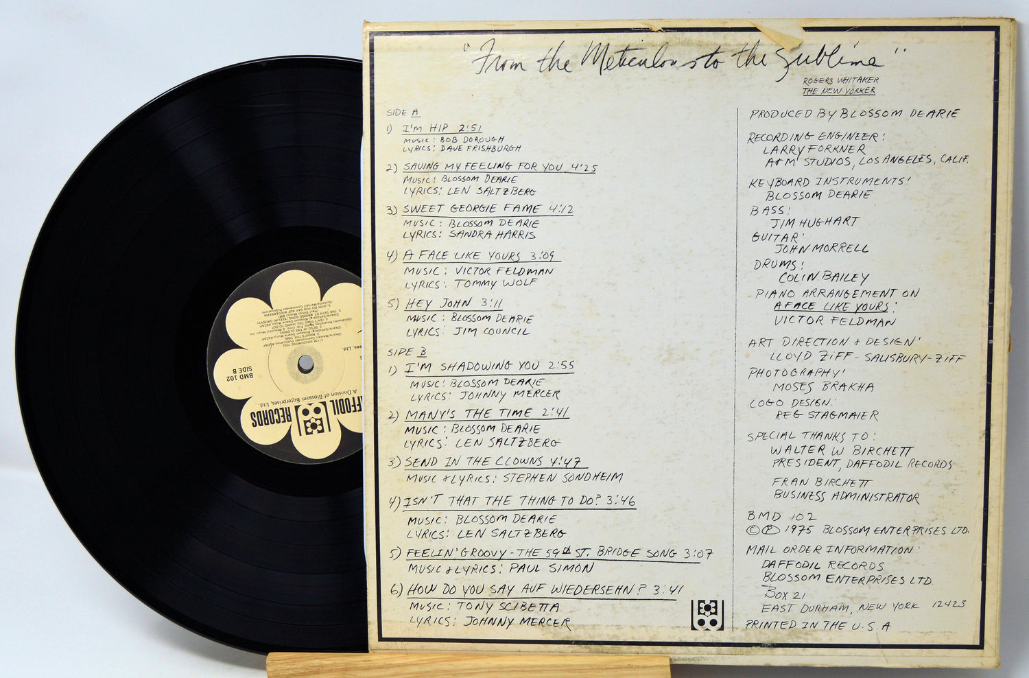 Vinyl record with a cover displaying track listings on a light gray background