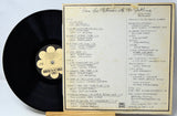 Vinyl record with a cover displaying track listings on a light gray background