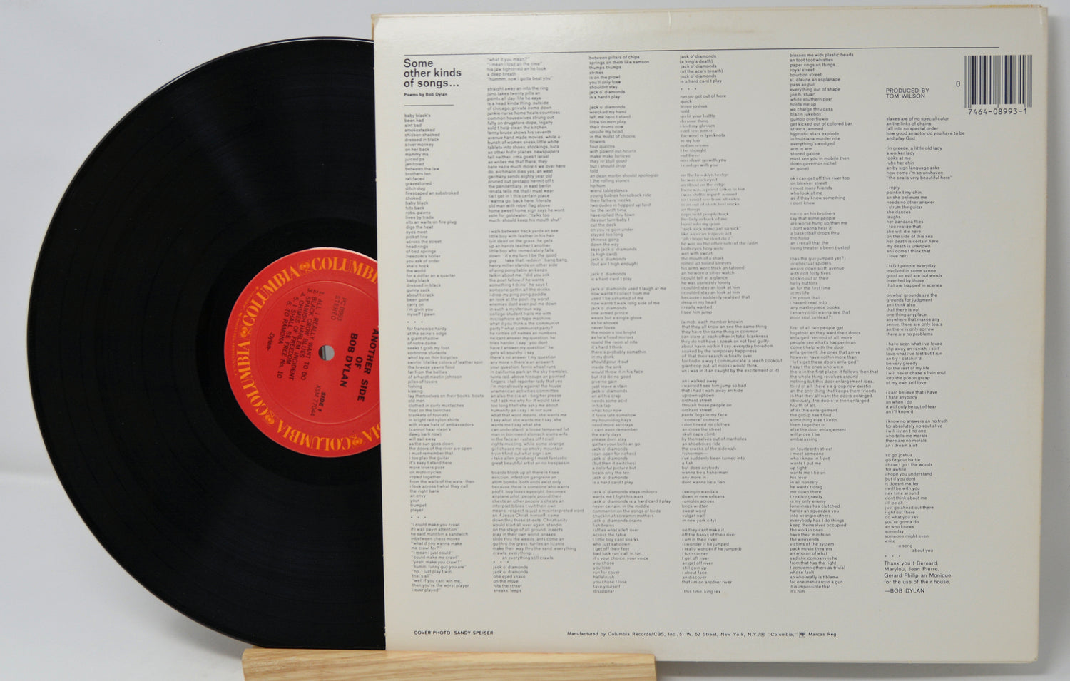 Vinyl record with a red label and its back cover displaying a list.