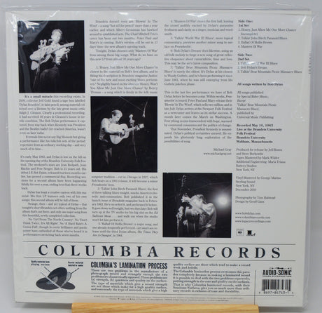 The back cover of a Columbia Lamination Records music release, featuring track listings, biographical text, and black-and-white photos of a performer on stage, sealed in a plastic sleeve.