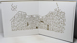 An open book or printed booklet on a white surface, showing a detailed topographic-style map drawn in brown ink with handwritten text throughout the pages.