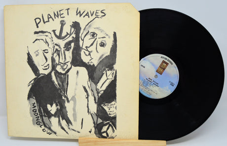 Vinyl record with 'Planet Waves' cover featuring artistic illustrations on a light gray background