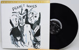 A vinyl record album shown with its illustrated outer sleeve and the black record partially pulled out. The sleeve reads 'PLANET WAVES' and 'ORIGINAL MASTER RECORDING.