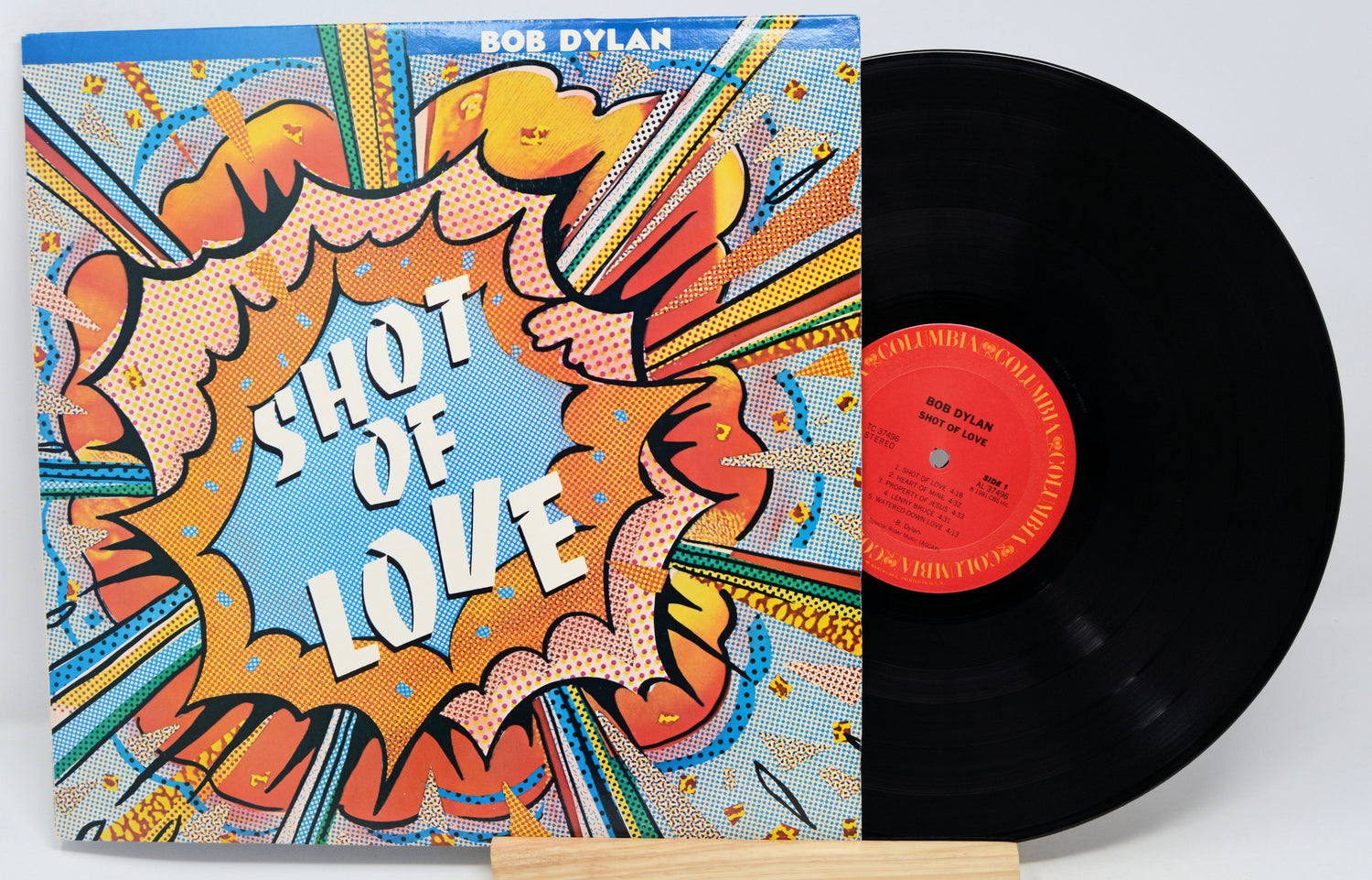 Vinyl record with a colorful cover featuring 'Shot of Love' by Bob Dylan