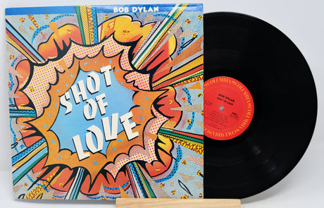 Vinyl record with a colorful cover featuring 'Shot of Love' by Bob Dylan