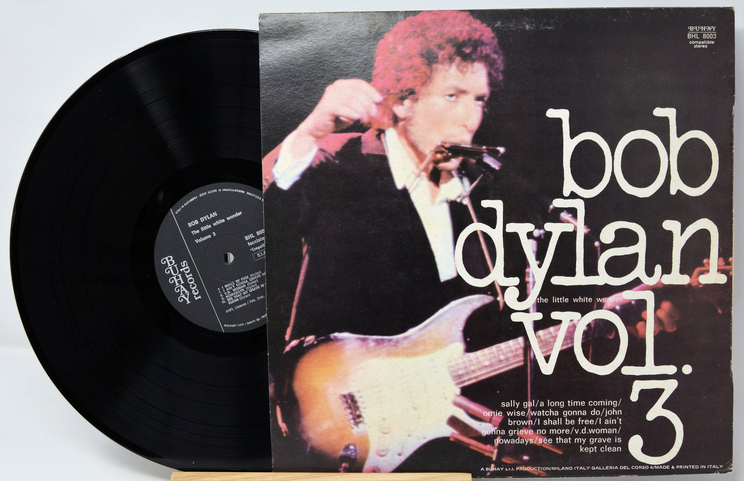 Vinyl record with cover featuring Bob Dylan playing guitar, on a light gray background.