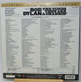 Back cover of a Bob Dylan vinyl record showing the track listing for '11 Outlined Epigrams: They Are Dylan a Changelin', with the Bob Dylan name in large black text and a gold 'Original Master Recording' banner at the top.