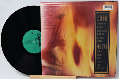 Vinyl record with yellow label and blue cover displaying tracklist on a white background