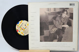 Vinyl record with a black label and a photo of a person on the cover