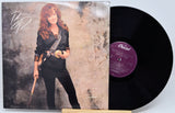 Bonnie Raitt 'Nick You're Mine' vinyl record LP with the album cover standing on a small wooden stand next to the black vinyl disc, showing the purple Capitol label.