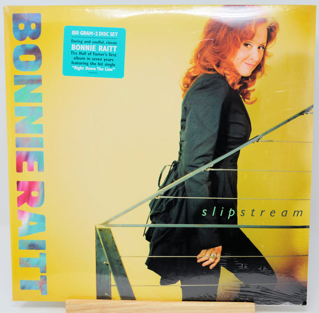 Bonnie Raitt's 'Slipstream' 2-CD box set vinyl record cover, sealed in plastic shrink wrap, displayed on a wooden stand against a white background.