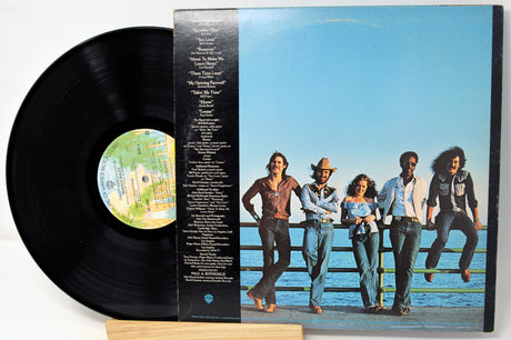 Vinyl record with cover featuring a group of people on a dock.