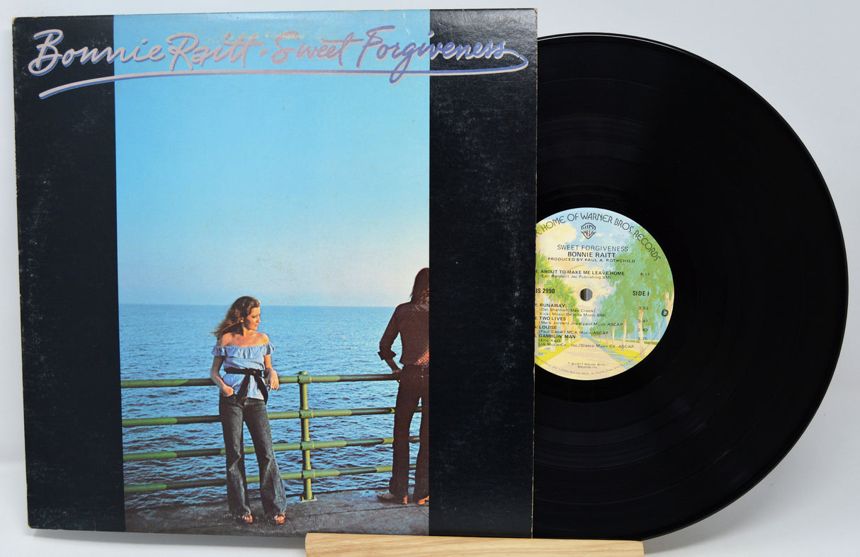 Vinyl record with cover featuring a couple by the sea, titled 'Bonnie Raitt - Sweet Forgiveness'.