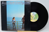 Vinyl record with cover featuring a couple by the sea, titled 'Bonnie Raitt - Sweet Forgiveness'.