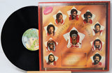 A vinyl record partially pulled from its illustrated album cover, showing a black record on a white background. The cover reads 'Player of the Year Award' and features multiple portrait illustrations of a man in red and white clothing against a warm orange-brown background.
