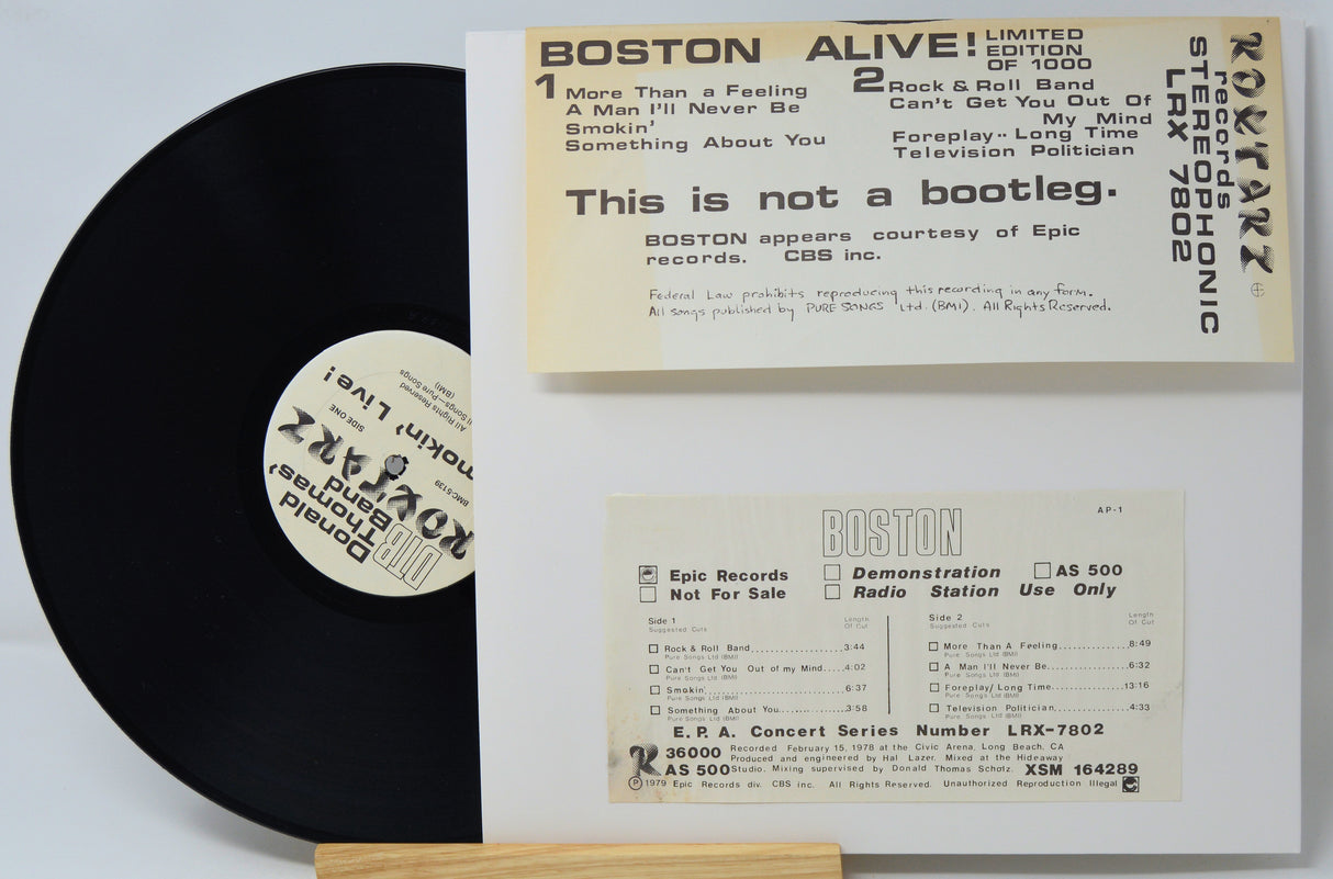 Vinyl record with a white label and a cardboard sleeve displaying text about the album 'Boston Alive!'.