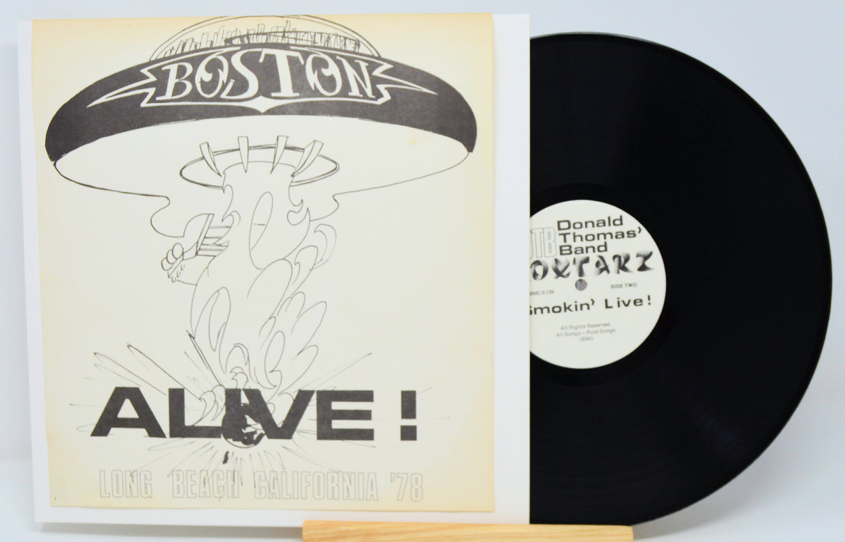 Vinyl record with cover featuring 'Boston' and 'Alive!' text on a white background