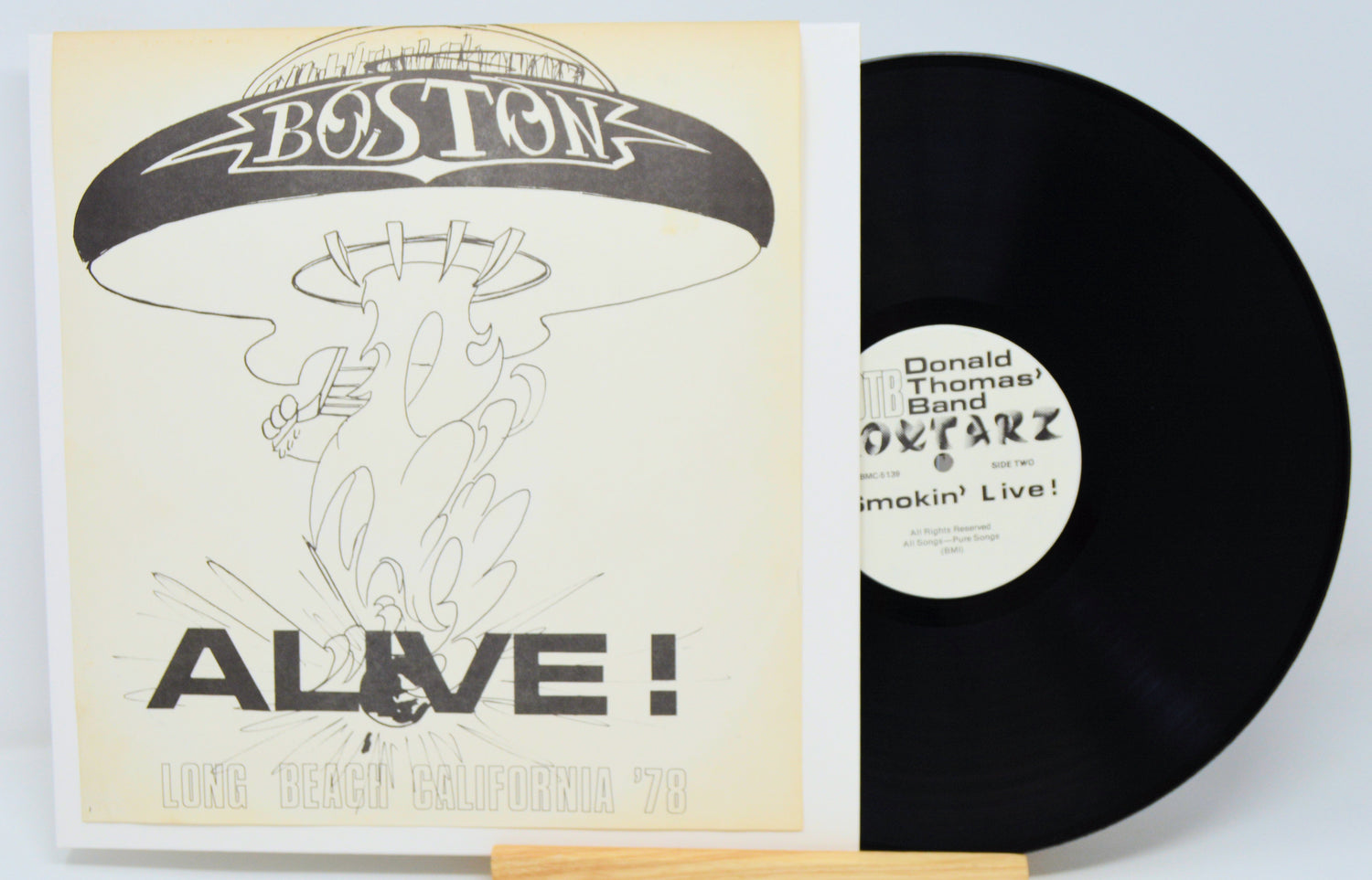 Vinyl record with cover featuring 'Boston' and 'Alive!' text on a white background