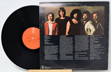 Vinyl record with a black cover featuring a band's portrait and tracklist.