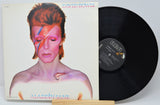Vinyl record and cover of David Bowie's 'Aladdin Sane' album on a white background