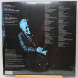 The back cover of a vinyl record sleeve for Steve Jordan's album 'Side Two', displayed on a wooden stand against a white background.