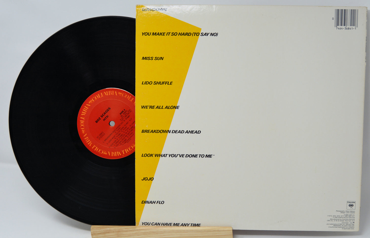 Vinyl record with yellow label and white sleeve on a white background