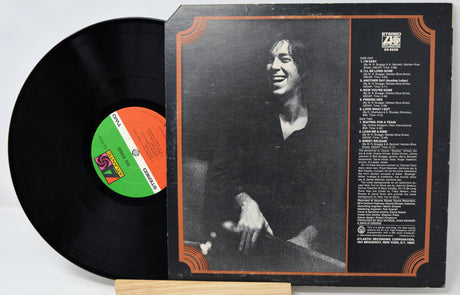 Vinyl record with a smiling person on the cover and a visible label.