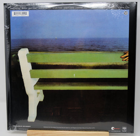 A vinyl record sleeve for Bob Dylan's album 'The Freeway' on Columbia Records, sealed in plastic shrink wrap. The cover art features a green wooden bench overlooking a blue ocean under a blue sky, with a hand resting on the right edge.