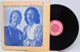 Vinyl record with cover featuring two people and a pink label on a white background