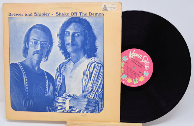 Vinyl record with cover featuring two people and a pink label on a white background