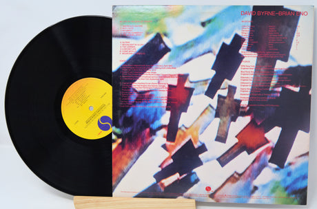 Vinyl record with a colorful cover featuring abstract designs and text.