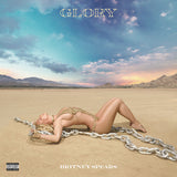 Britney Spears posing in a gold outfit with chains on a desert landscape for the Glory album cover