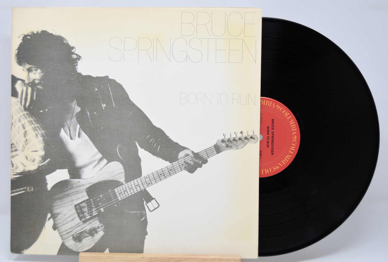 'Bruce Springsteen Born To Run' Vinyl record with a cover featuring a black and white image of Bruce playing guitar