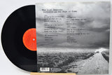 Vinyl record album shown with the black LP partially pulled from the back cover, which features a black-and-white landscape photo and the title 'The Lost Sessions: Darkness on the Edge of Town.'.