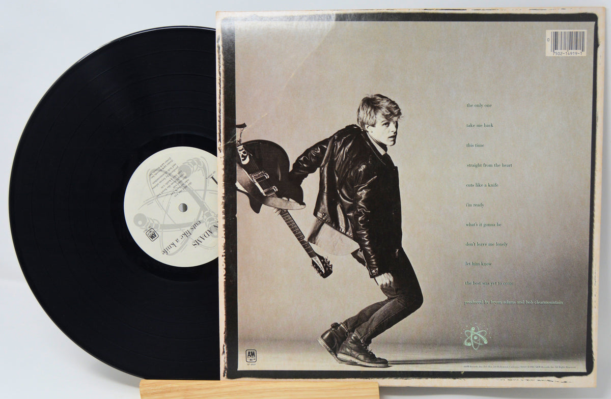 Vinyl record with its cover featuring a person playing guitar on a light background