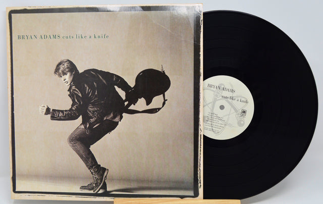 Vinyl record with cover featuring a silhouette of a person playing guitar, on a white background.