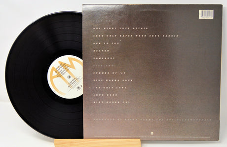Vinyl record with a brown cover featuring text on a white background