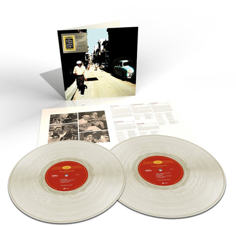 Vinyl records with a cover featuring a street scene and additional documents on a white background