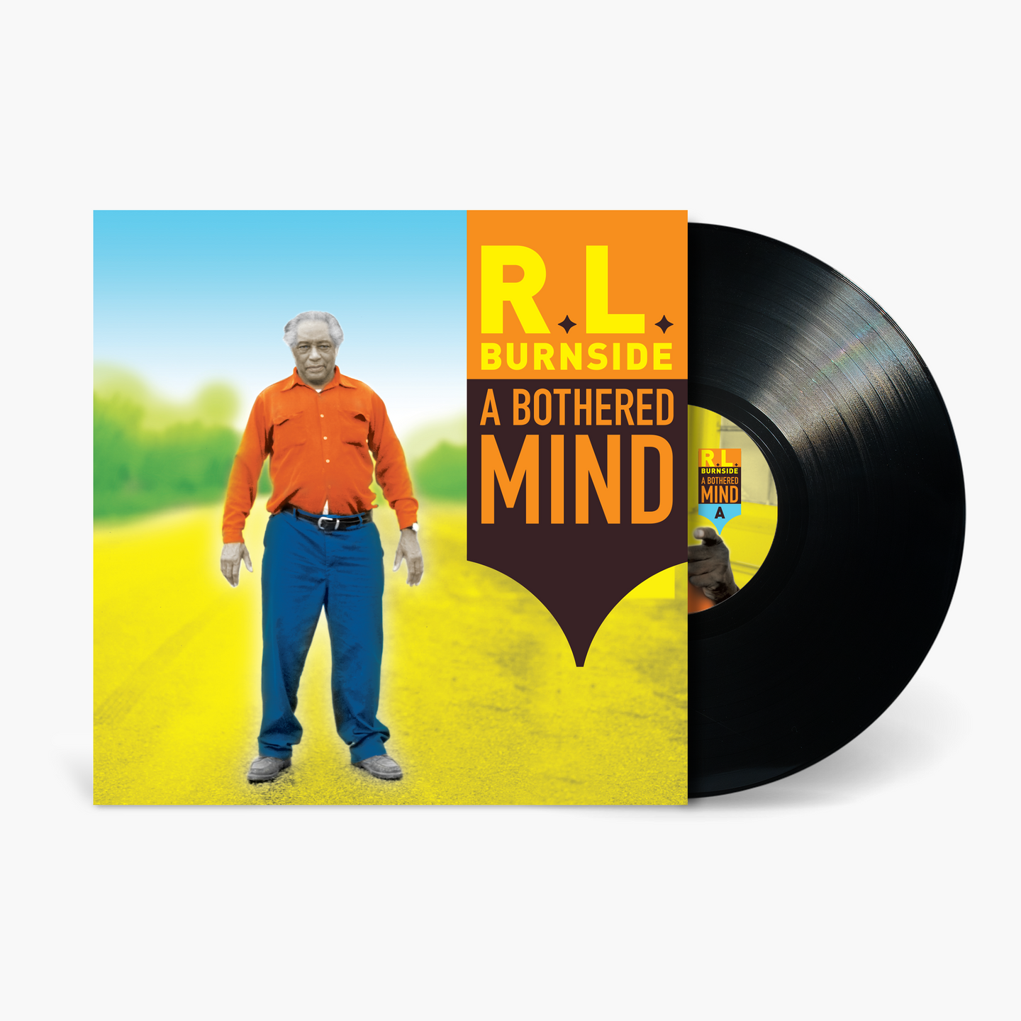 Vinyl record with cover featuring a man in an orange shirt and blue pants standing in a field.