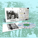 Vinyl record with cover and additional materials on a textured green background
