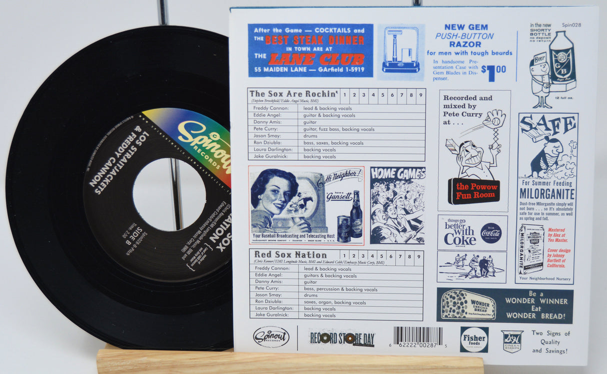 Vinyl record with a colorful label and a vintage magazine or newspaper on a white background
