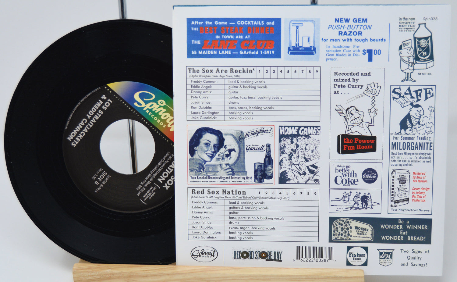 Vinyl record with a colorful label and a vintage magazine or newspaper on a white background