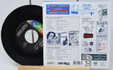 Vinyl record with a colorful label and a vintage magazine or newspaper on a white background