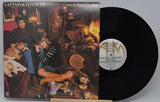 Vinyl record with cover featuring two people and a dog in a cozy room setting.