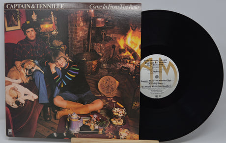 Vinyl record with cover featuring two people and a dog in a cozy room setting.