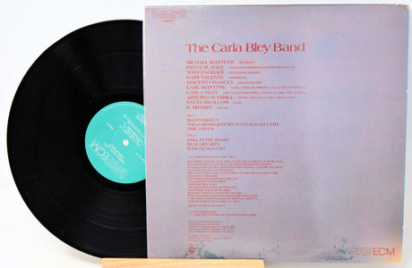 Vinyl record album shown with the black record partially pulled from the sleeve, featuring the title 'The Carla Bley Band' and a teal center label on a white background.