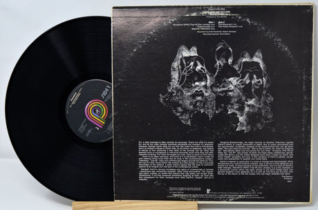 Vinyl record with cover featuring abstract design and text on a light gray background