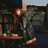 Album cover with a person in a leather coat sitting at a table, surrounded by abstract elements.