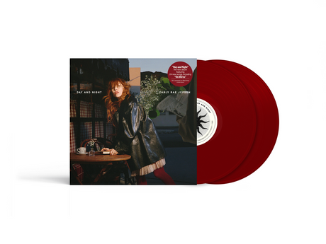 Red vinyl record with a cover featuring a person sitting at a table, on a white background.