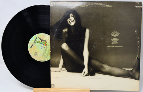 Vinyl record with a black cover featuring a stylized image of a woman.